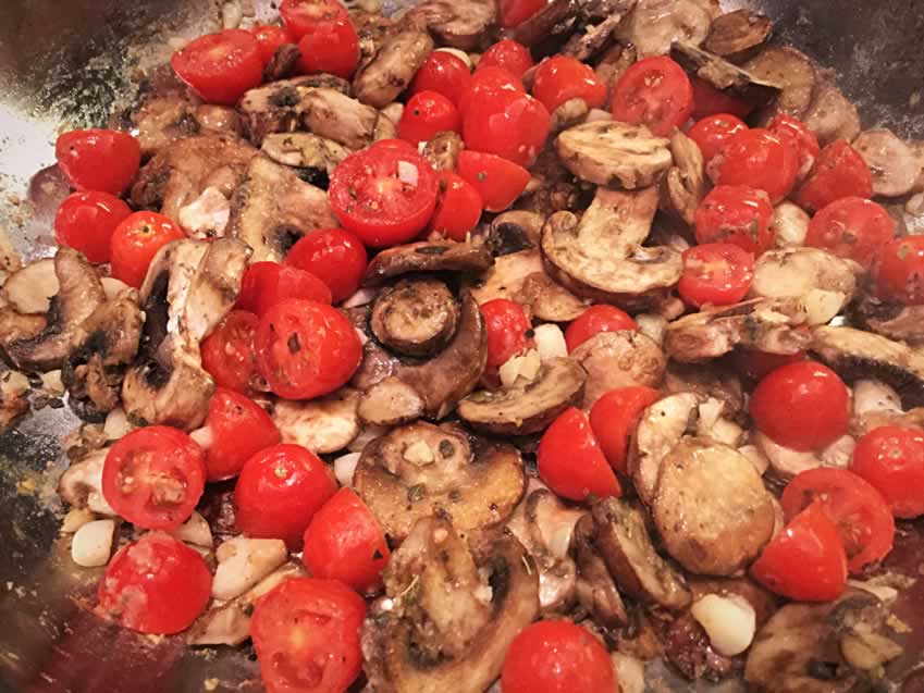 Sautéing the mushrooms, tomatoes, garlic and spices