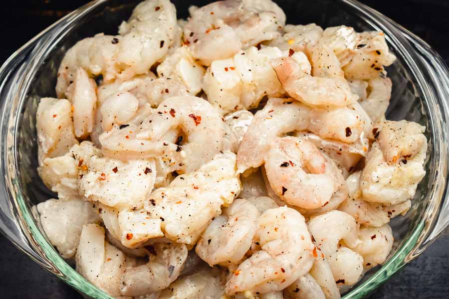 Shrimp and cod marinating in a casserole dish