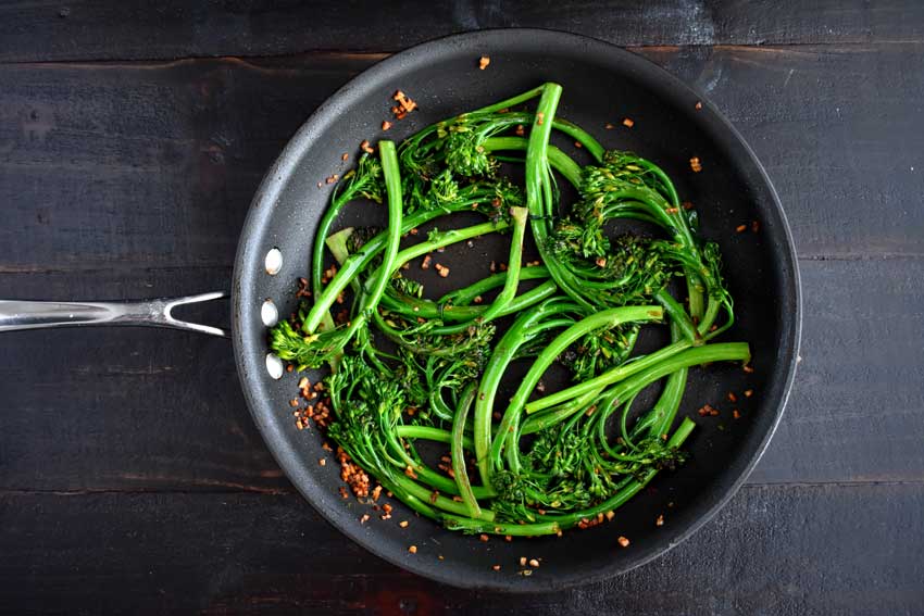 Broccolini and garlic in the skillet