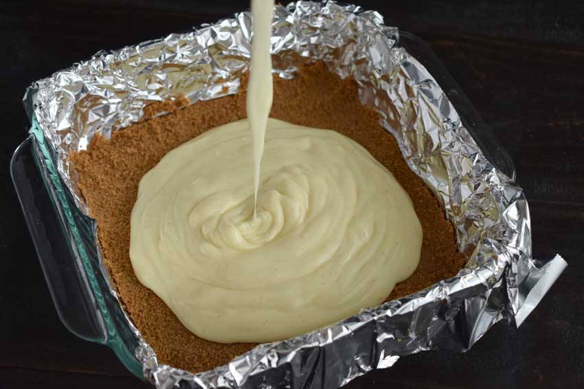 Pouring the filling onto the baked graham cracker crust