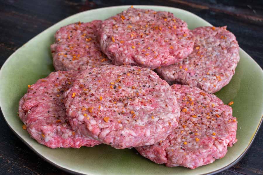 Seasoned hamburger patties ready to go onto the grill