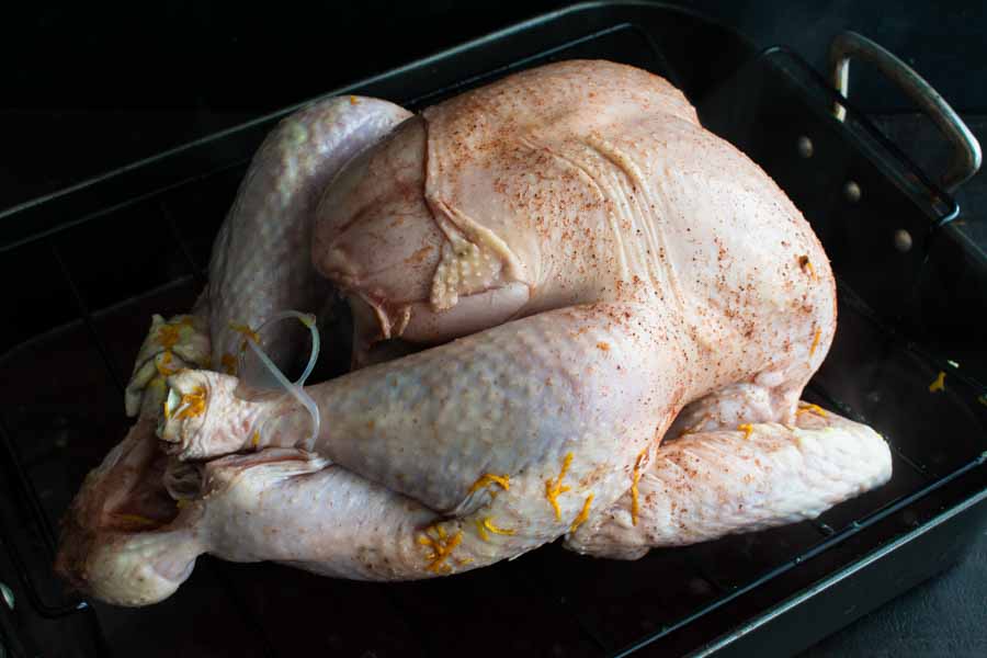The prepped turkey on a roasting rack