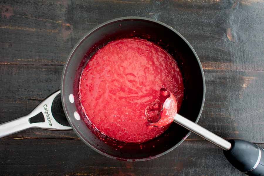 Pureeing the raspberries with an immersion blender
