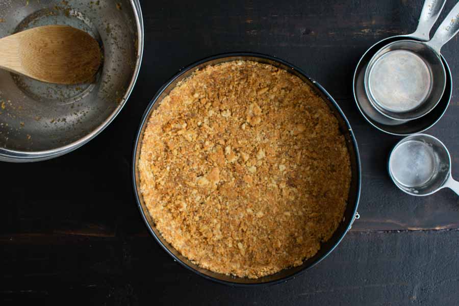 The graham cracker crust is pressed into the springform pan and ready to be baked