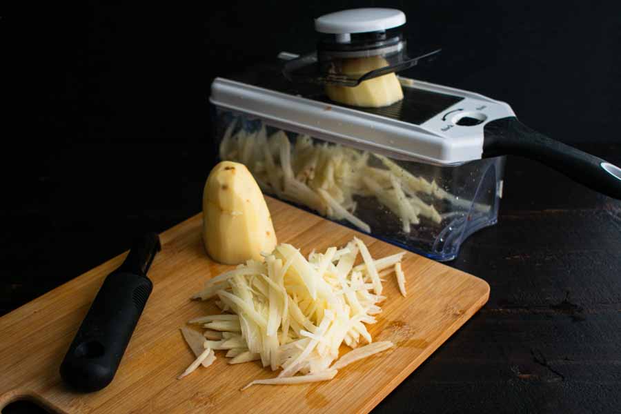 Using a mandoline to julienne the potatoes