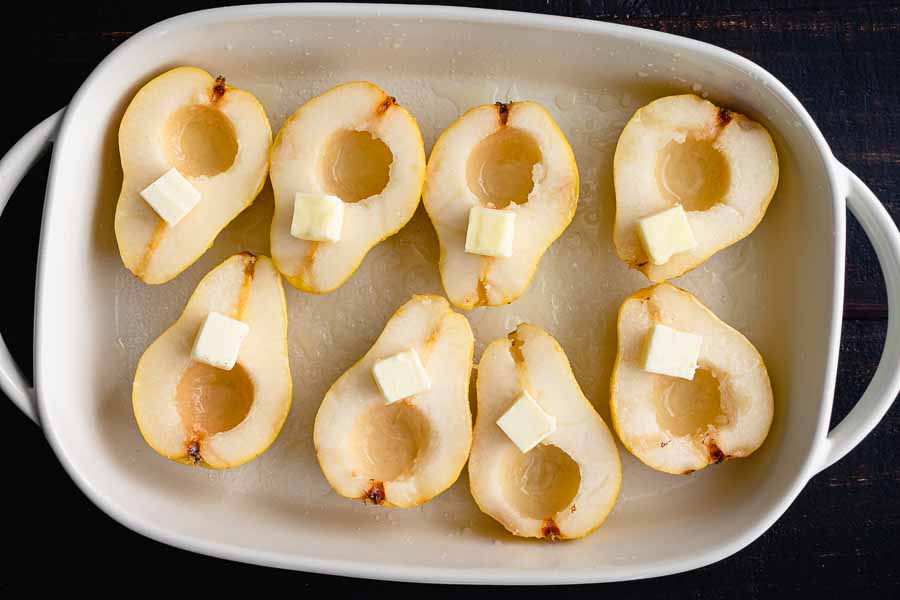 Cored pears sprinkled with lemon juice and sugar and topped with butter