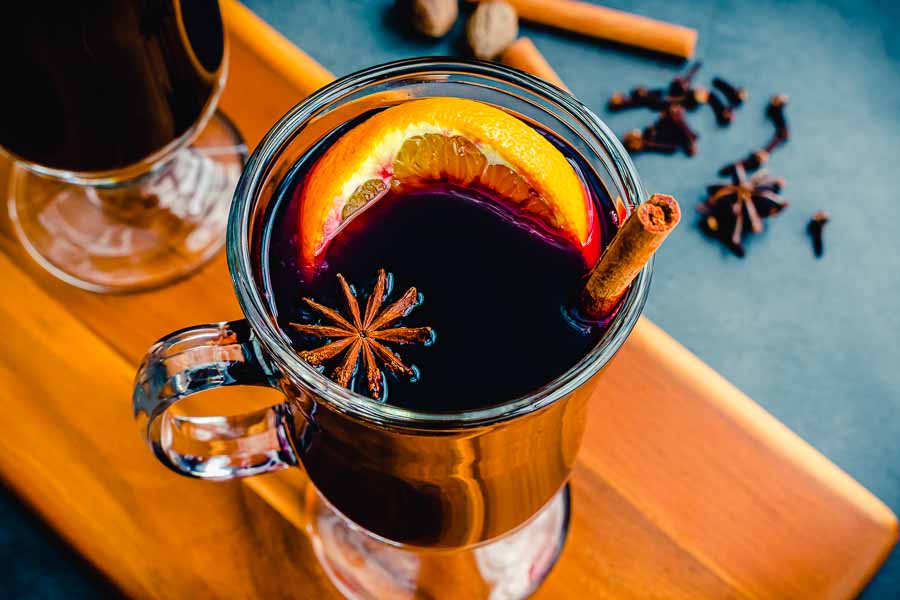 Mulled wine garnished with an orange slice, cinnamon stick, and a piece of star anise
