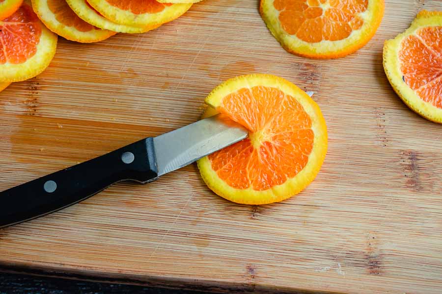 Cutting the orange slices to fit the muffin tin