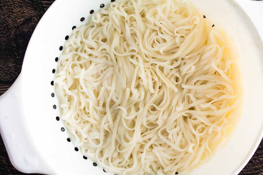 Cooked and strained rice noodles in a colander