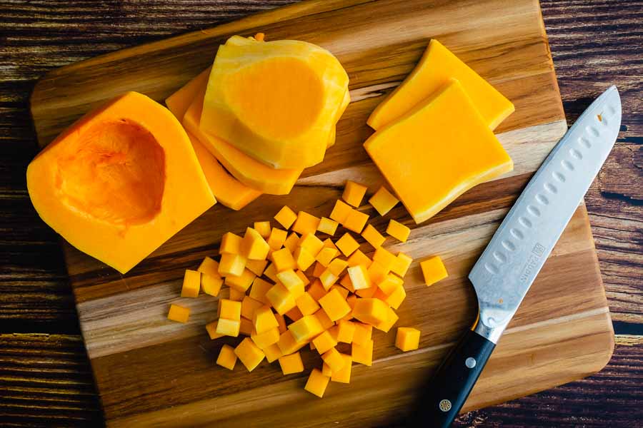 Slicing the peeled butternut squash into small cubes