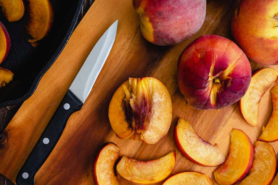 Slicing the clingstone peaches with a paring knife
