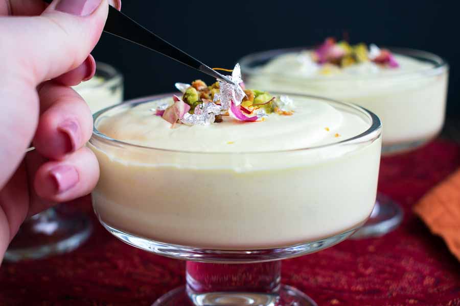 Garnishing the Ras Malai Mousse with edible silver foil