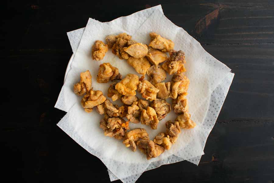 Fried chicken chunks draining on paper towels