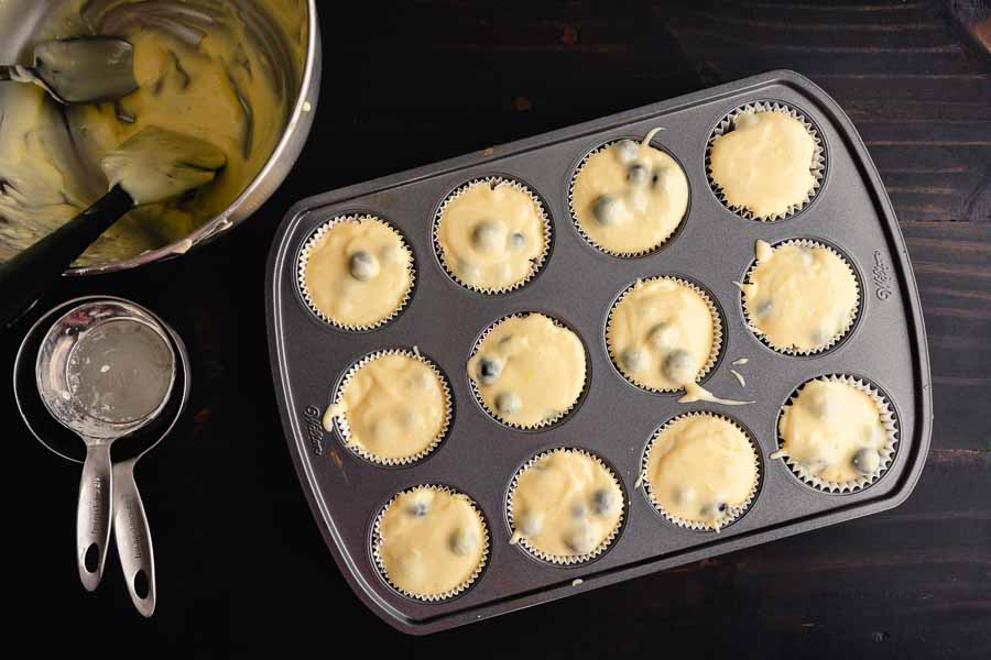 Muffin pan filled with blueberry muffin batter