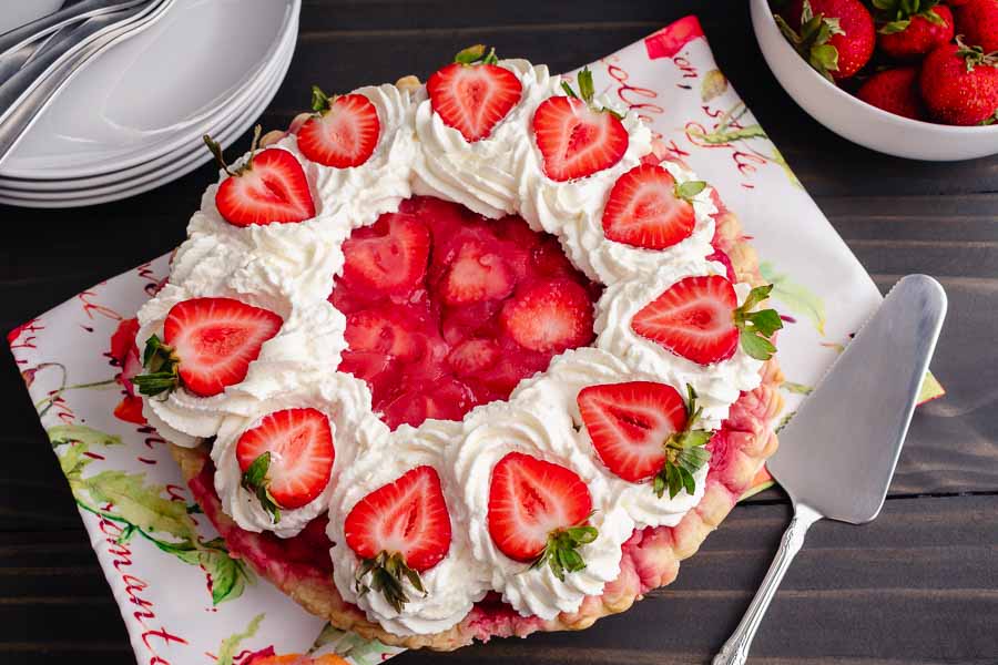 Strawberry Cream Pie decorated with whipped cream and fresh strawberries