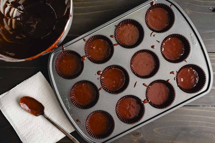 Lined cupcake pan filled with chocolate batter